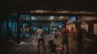 People in gym lift weights.
