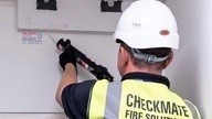 Checkmare fire installer uses sealant to gap seal cable compartment.