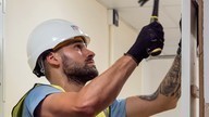 Fire door installer with a hammer fits a fire door.