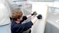 A Checkmate Fire employee measuring a partition as part of fire stopping installation work.