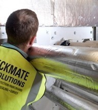 fire protection installer seals pipe gaps to create fire compartment