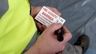 A Checkmate Fire installer writing a label as part of fire-stopping installation work.