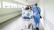 Nurse walks down hospital corridor.