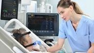 Nurse checks on bed bound patient.