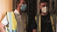 Two Checkmate Fire employees in face masks and high-vis vests carrying out a fire safety risk assessment.