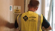A Checkmate Fire inspector carrying out inspection work on a fire door. 