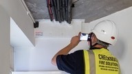 A Checkmate fire door surveyor taking a photograph of a ceiling as part of fire compartmentation survey.